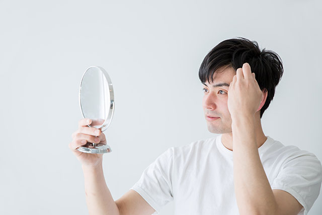 髪の毛を気にする男性