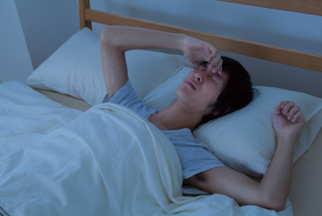 寝苦しそうな男性